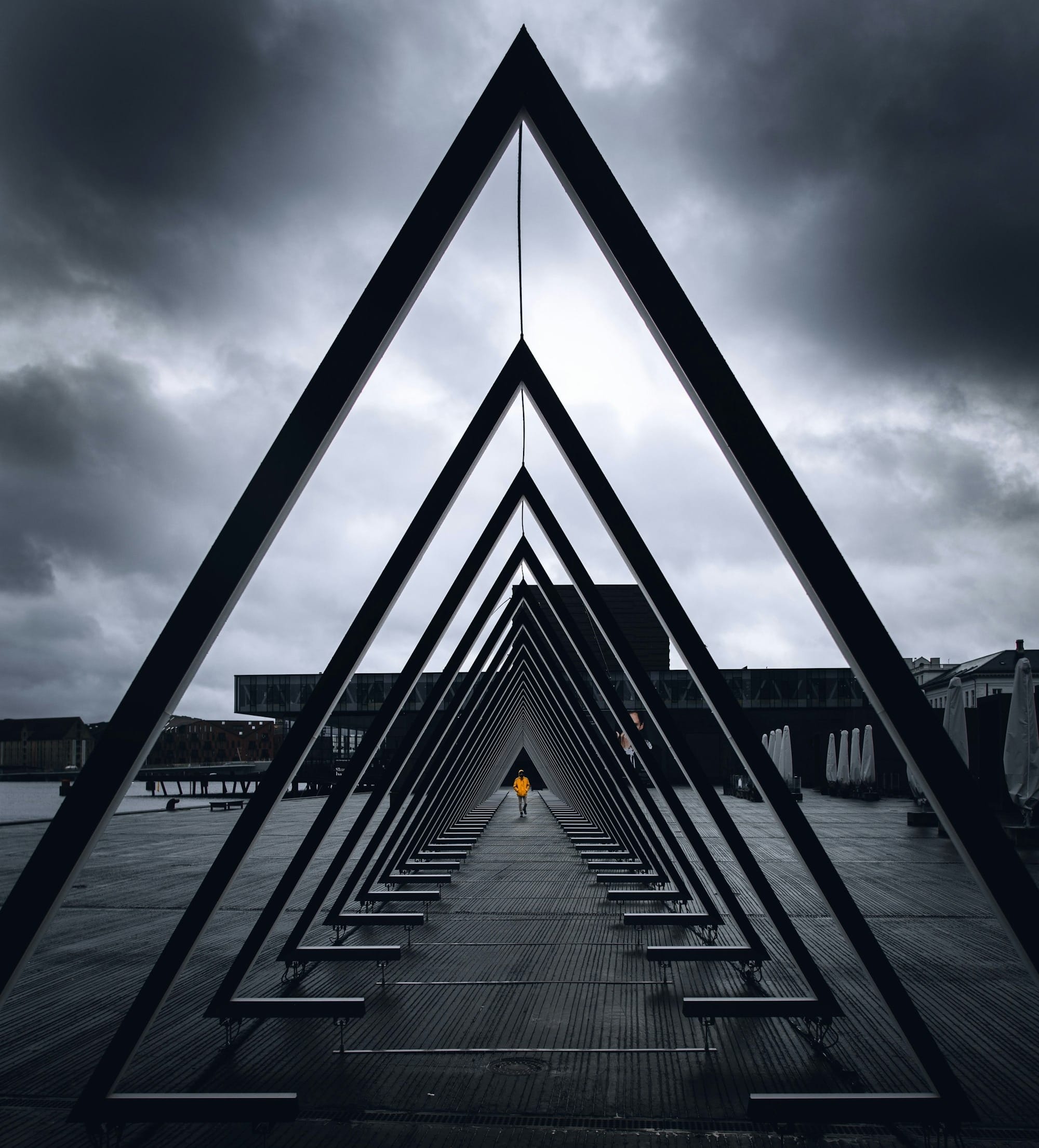 black metal bridge on sea under gray clouds
